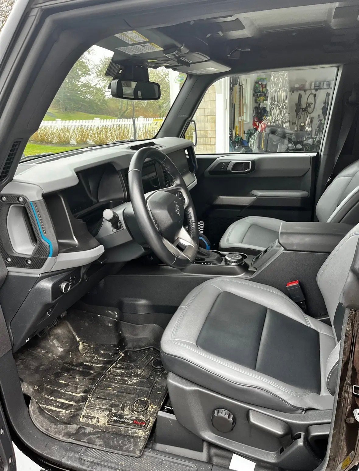 Interior view of a Land Rover vehicle showing steering wheel, dashboard, and front seats with two-tone black and gray upholstery
